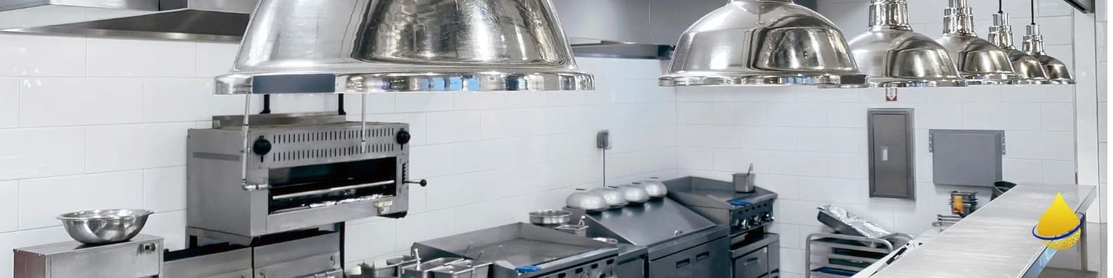 Stainless steel commercial kitchen with ventilation and prep equipment throughout.