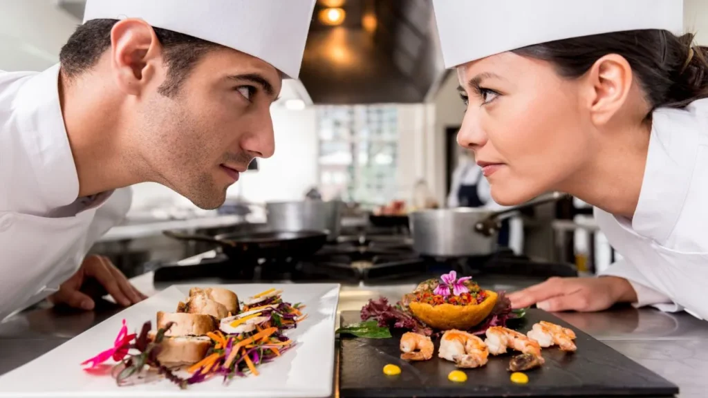 Chefs competing with gourmet dishes in professional kitchen