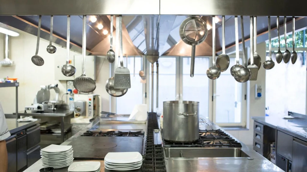 cookware and utensils hanging from the ceiling of a commercial kitchen
