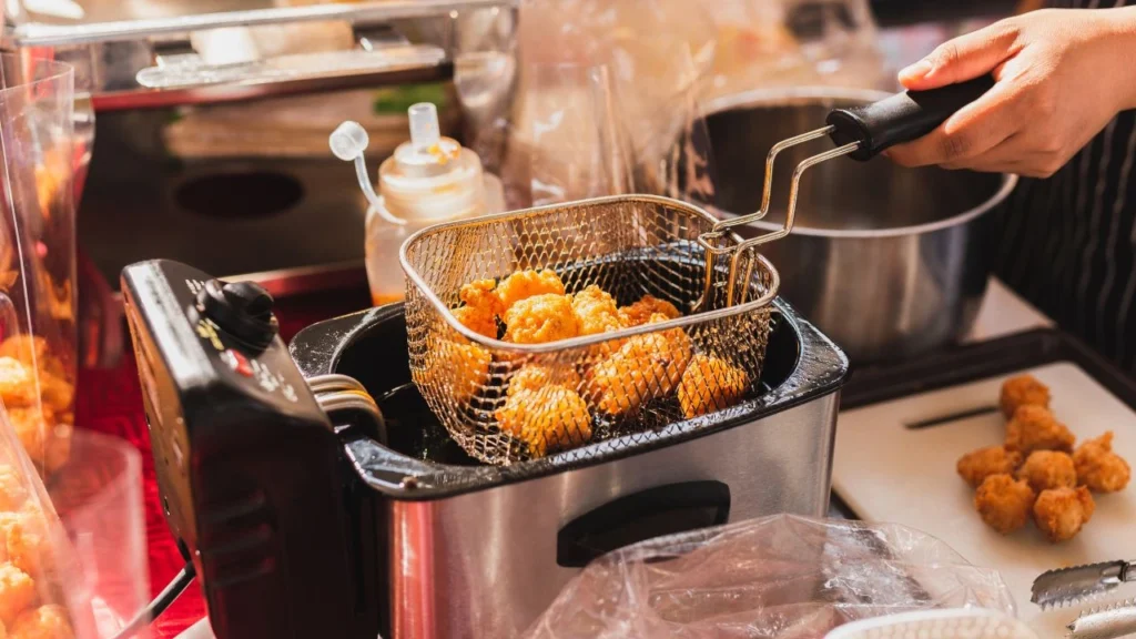 crowded commercial kitchen countertop with deep fryer