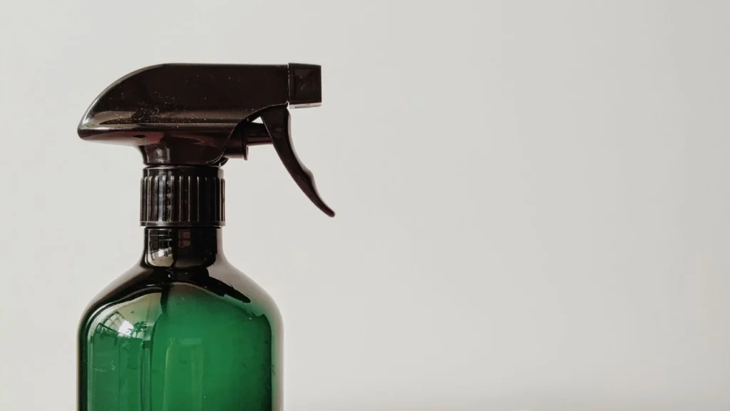 a green plastic bottle filled with cleaning agent