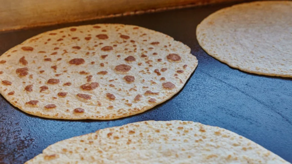 Large commercial kitchen griddle with tortillas