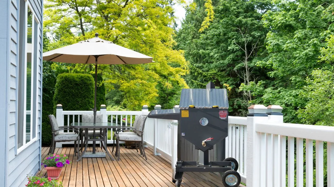 A Cajun fryer on a wooden deck patio with an outdoor dining area
