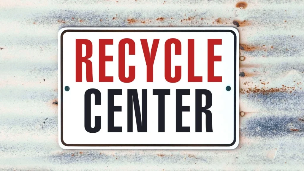 white sign with red writing displaying the words recycle center