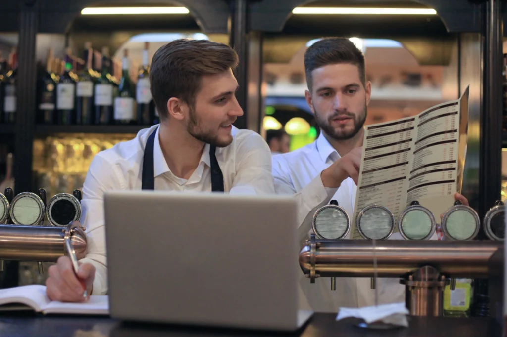 Restaurant kitchen employees reviewing inventory.