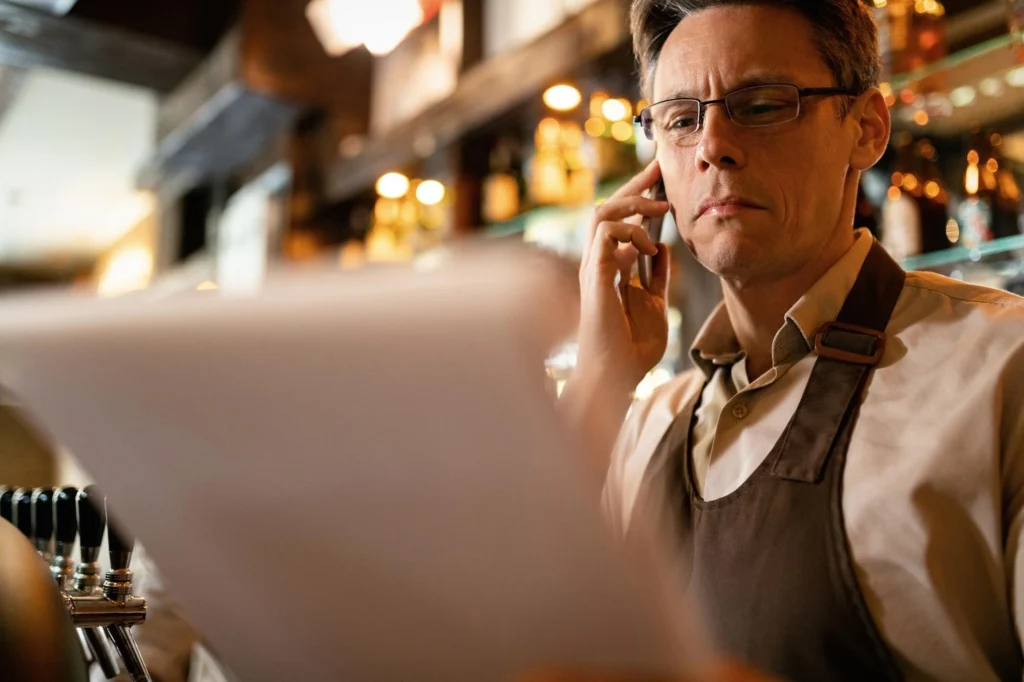 Manager reviewing documents and speaking on phone.