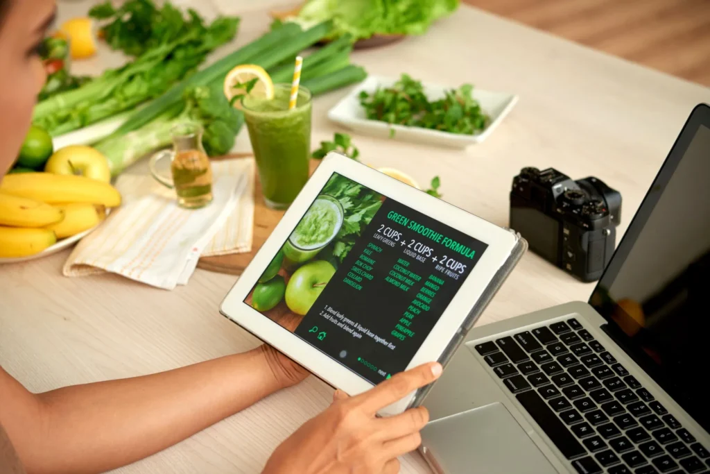 Tablet displaying smoothie recipe with fresh ingredients nearby.