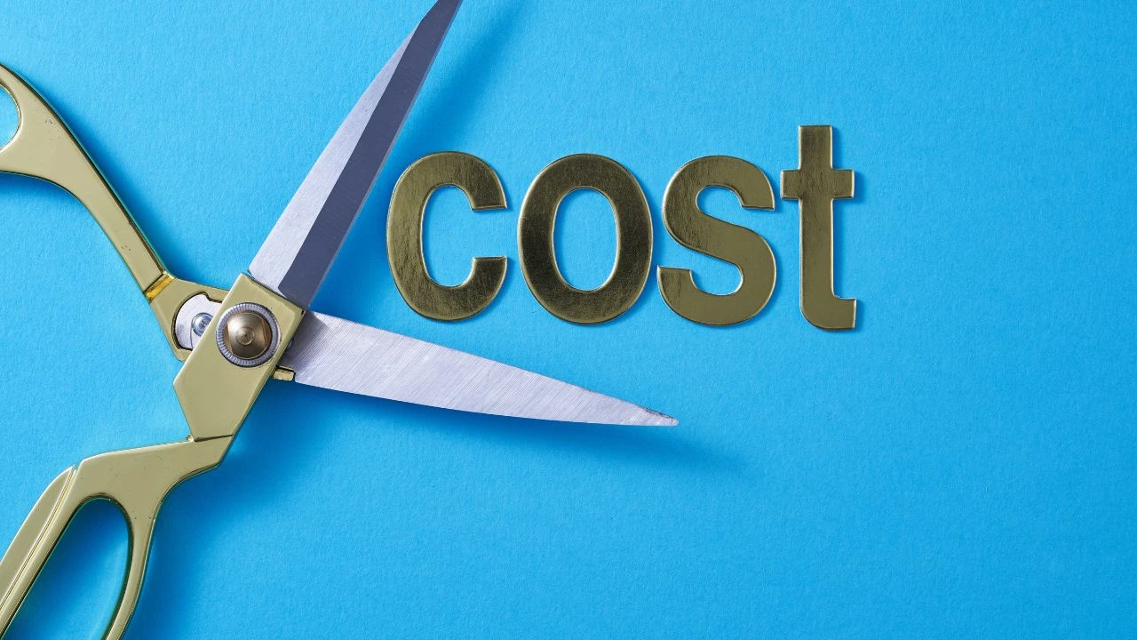 Scissors cutting cost text on blue background