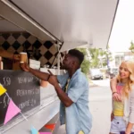 Customer taking coffee cup from food truck