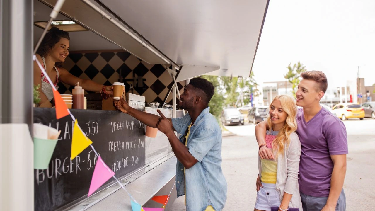 Customer taking coffee cup from food truck