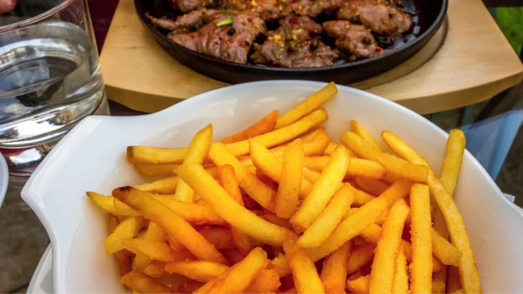 Golden french fries served alongside grilled meat dish
