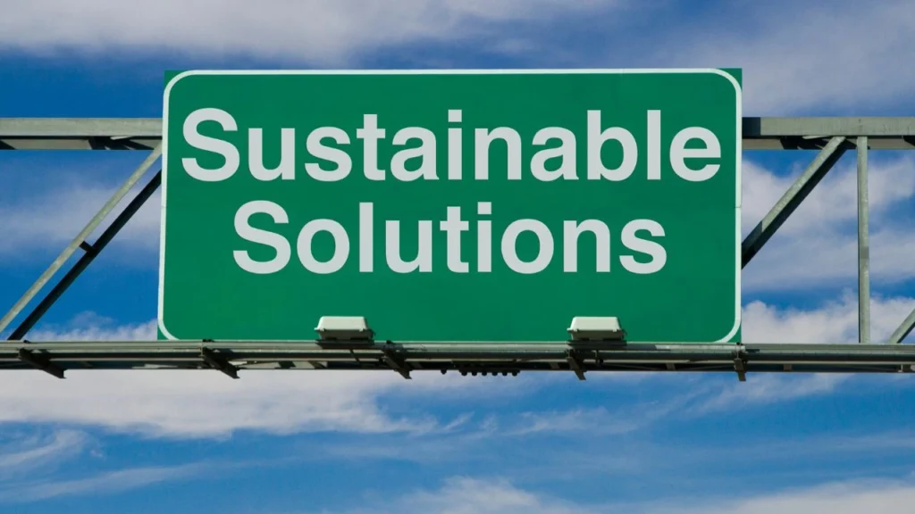 Green highway sign reading "Sustainable Solutions" outdoors