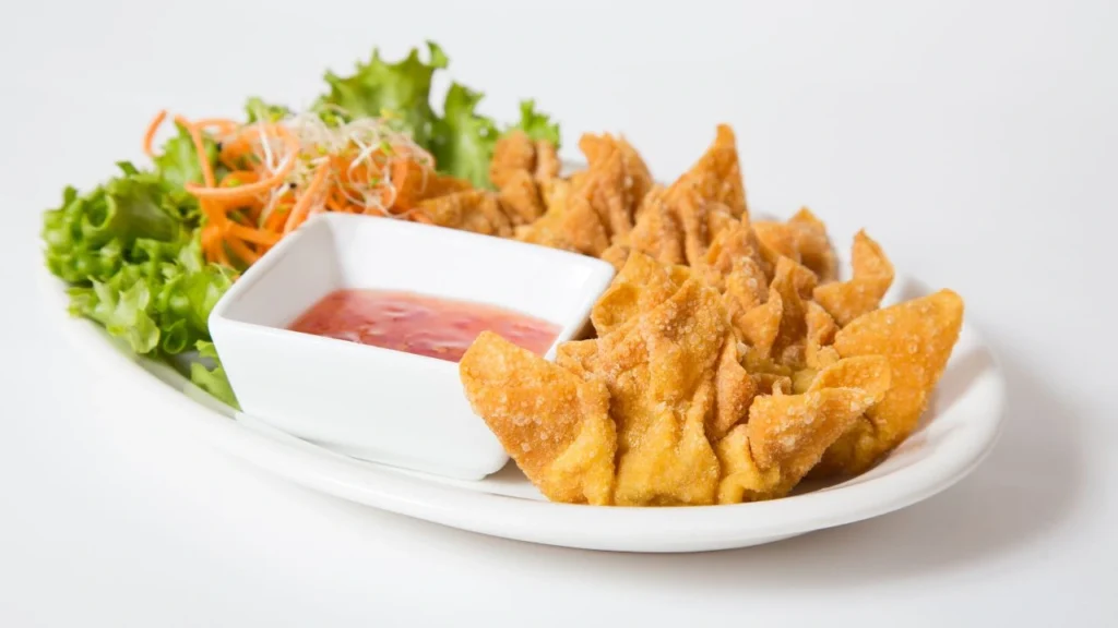 Fried wontons with sweet chili sauce and greens