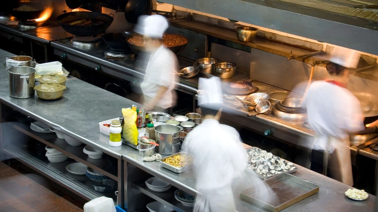 Busy commercial kitchen with chefs preparing meals efficiently