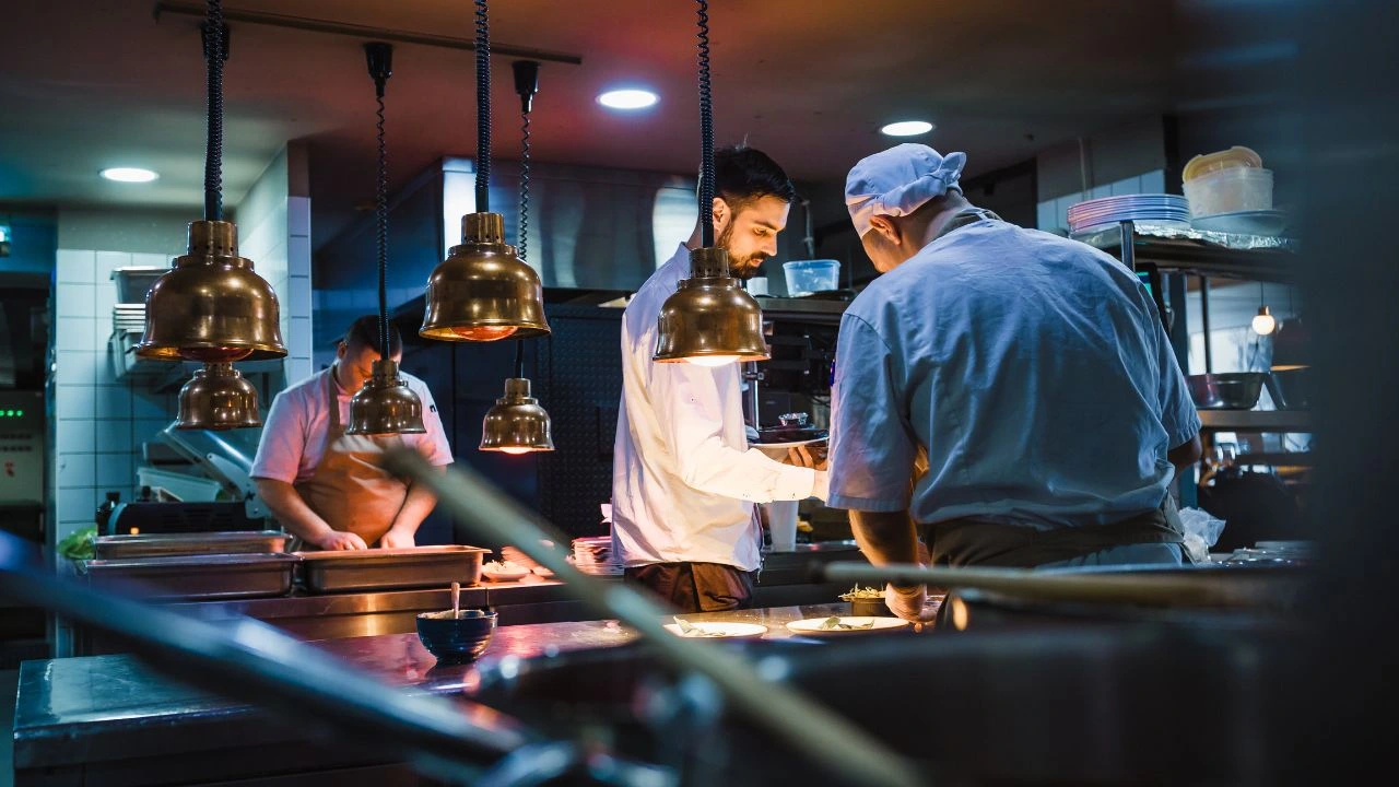 Chefs collaborating in busy, professional kitchen environment