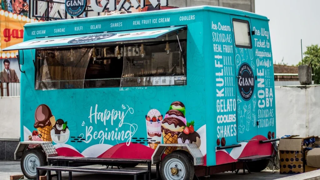 Bright blue ice cream truck with colorful dessert illustrations.