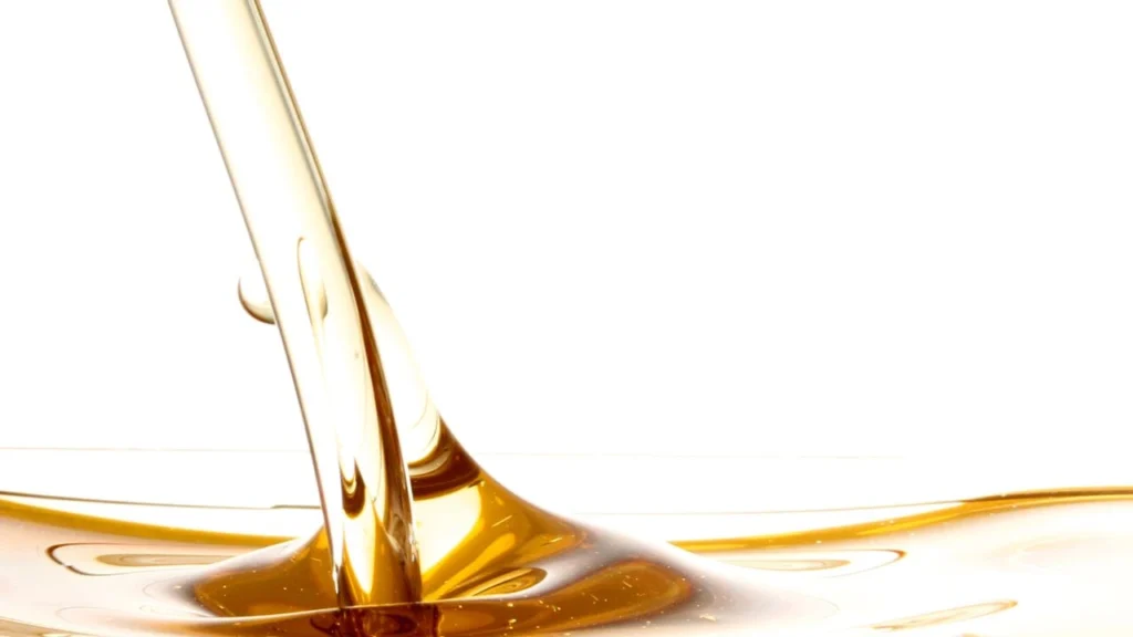 Flowing golden liquid representing oil usage reduction