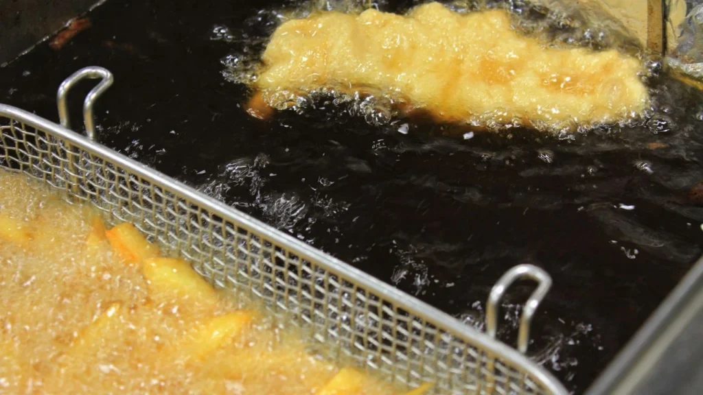 Golden fried food bubbling in dark oil