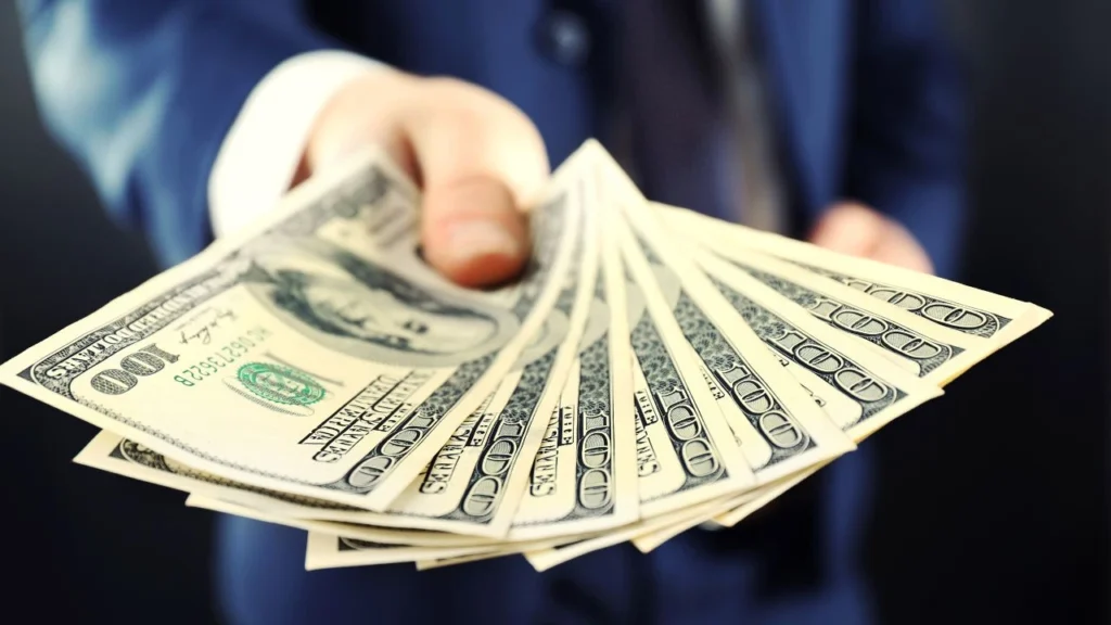 businessman giving money on a dark background
