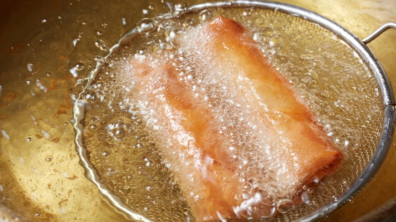 spring rolls frying in hot oil