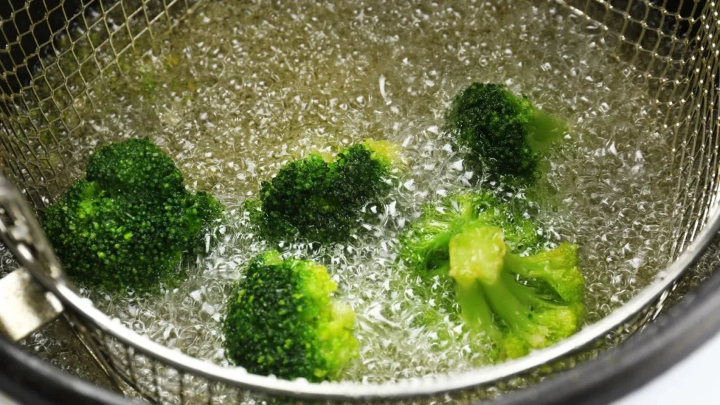 broccoli frying in fry oil basket