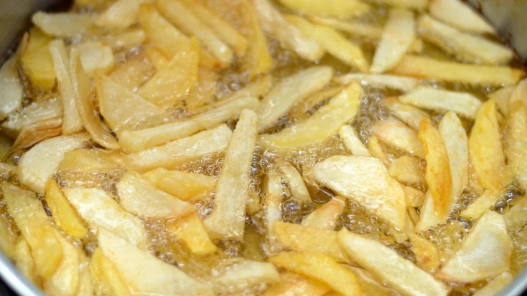 close up of potatoes frying in hot oil