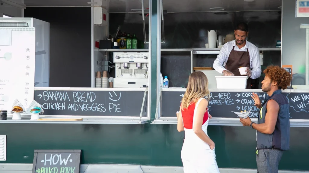 couple eating street food and talking to seller