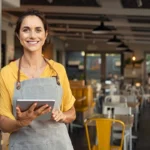 Smiling restaurant owner uses tablet to track digital trends