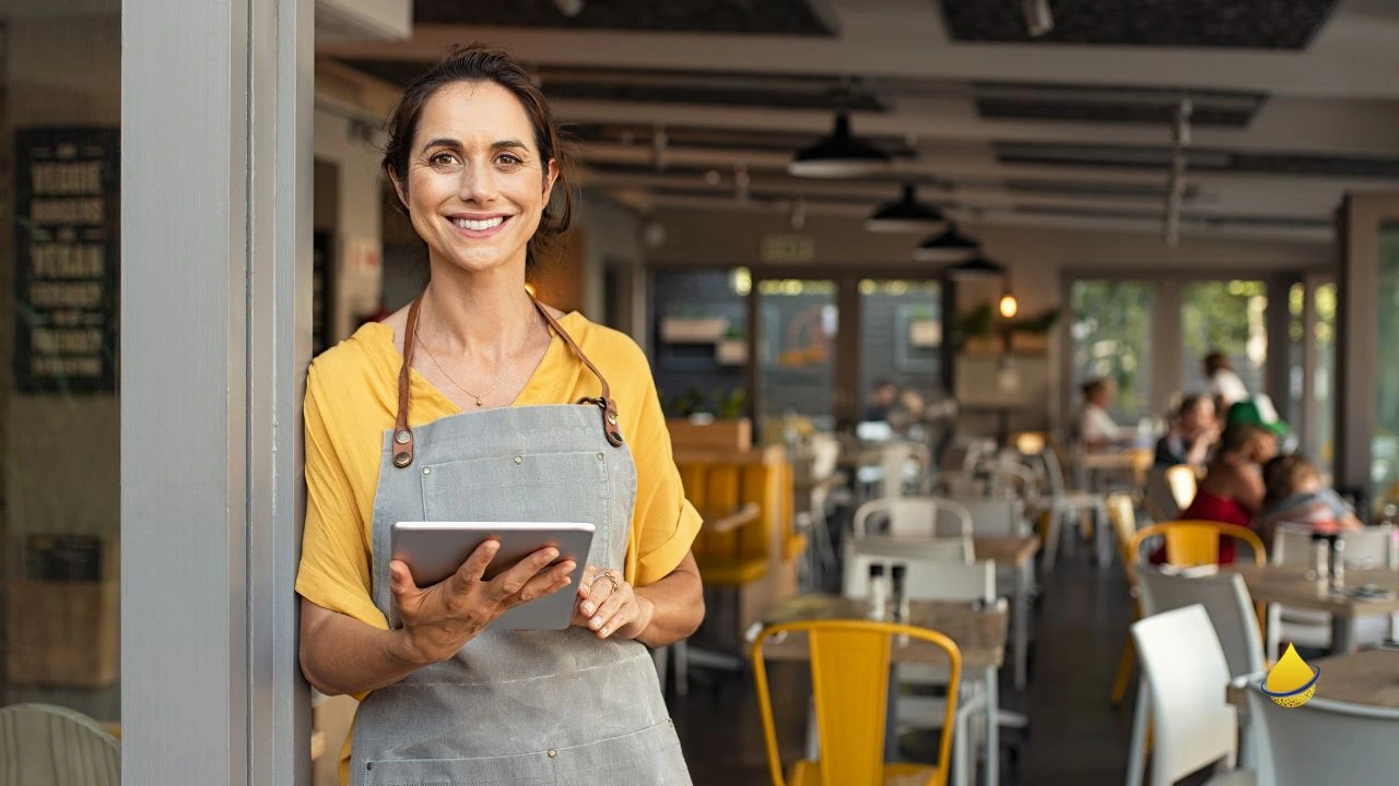 Smiling restaurant owner uses tablet to track digital trends