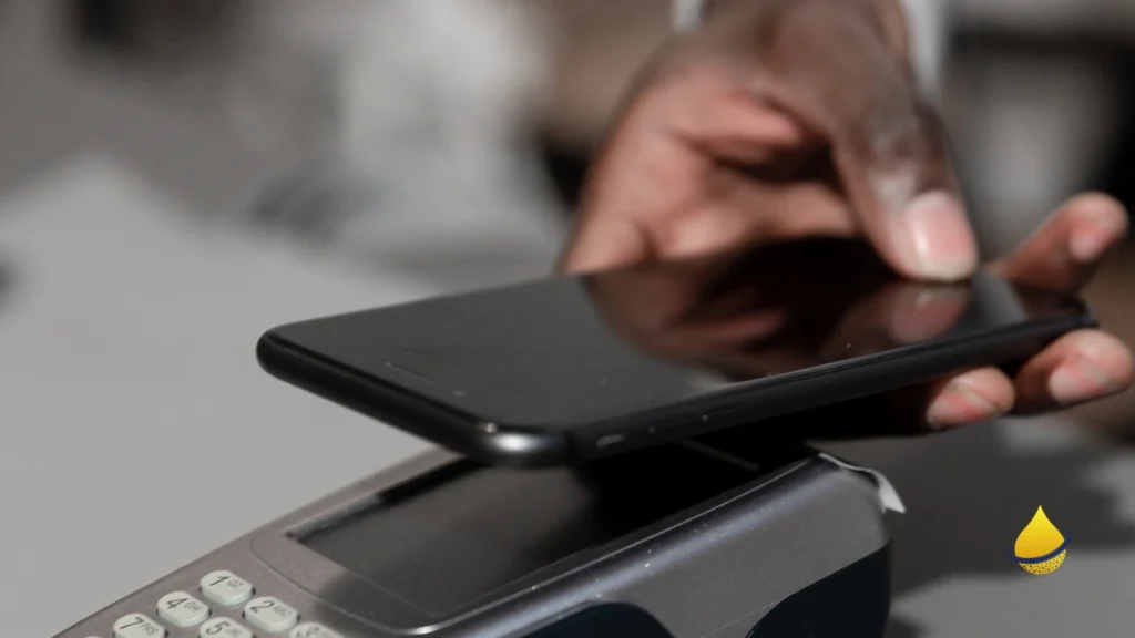 Person making contactless payment with smartphone on POS terminal.
