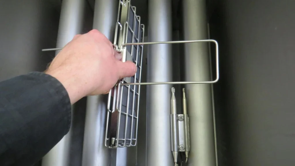 a hand showing the lowering of frylow into the deep fryer