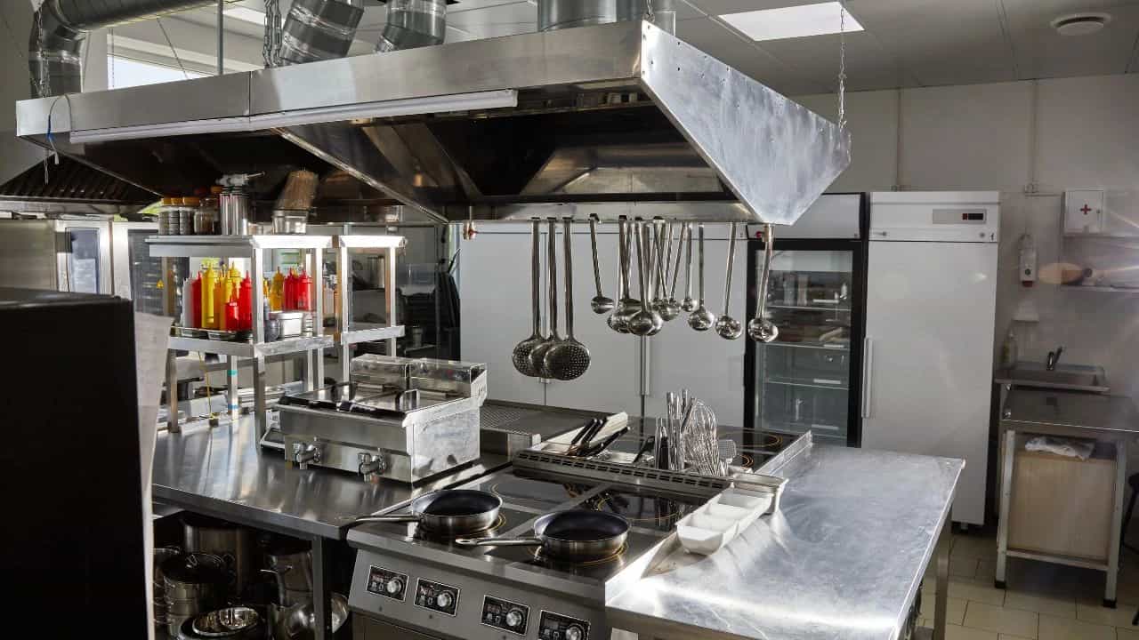 Chef cleaning a commercial kitchen, following professional hygiene tips.