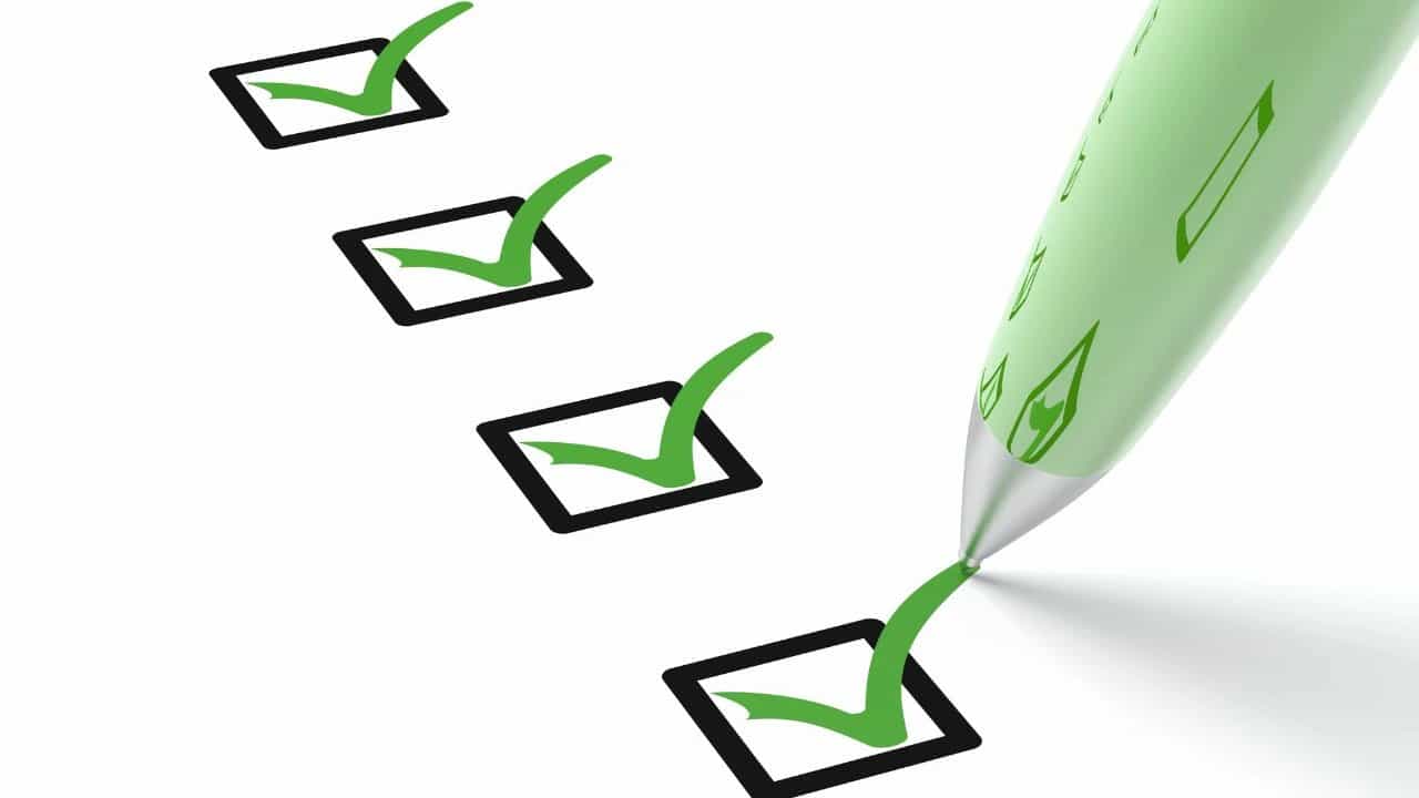 Green pen checking off boxes on a white inspection checklist.